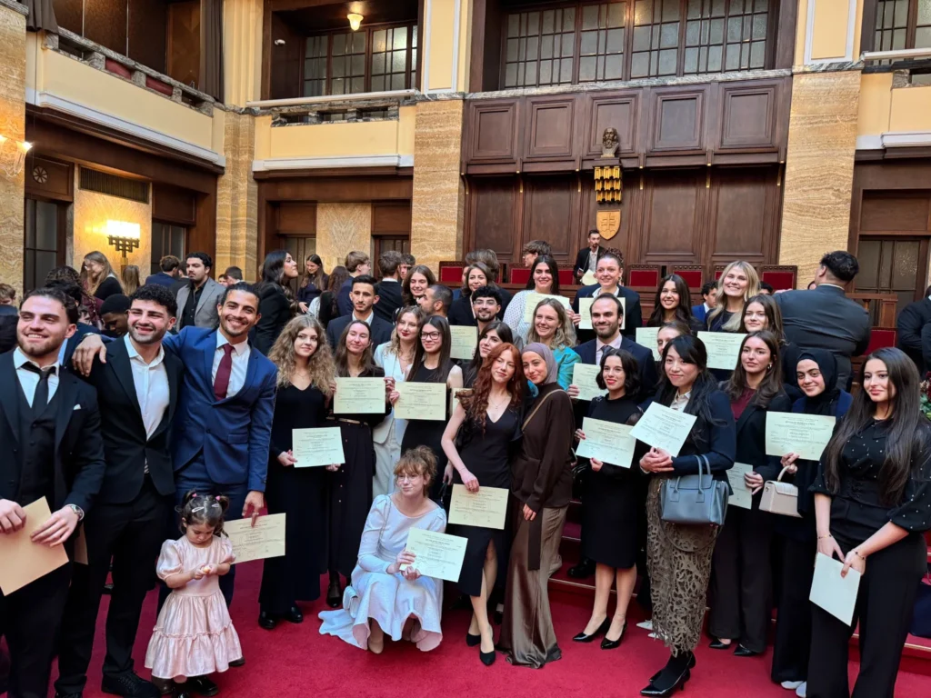 Students holding certificates at a university ceremony in Bratislava